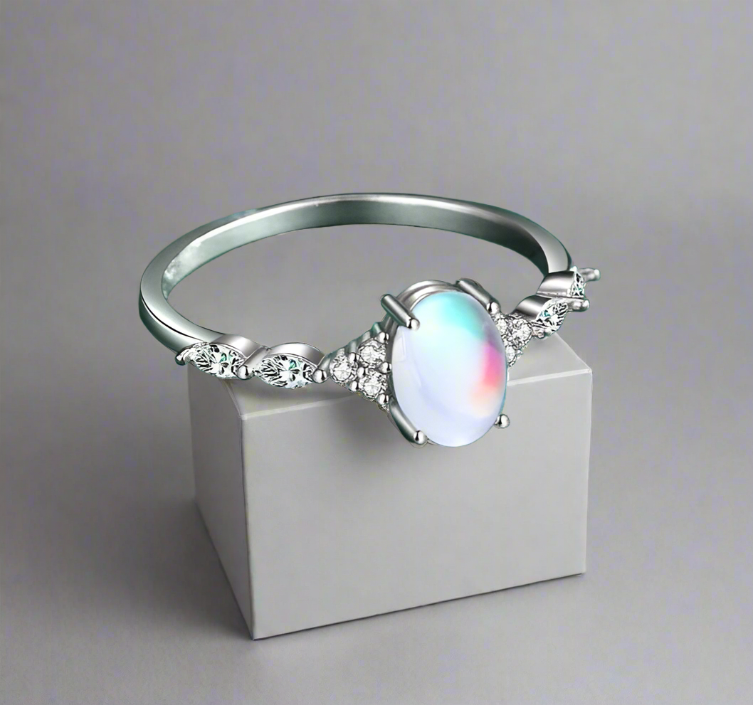 Elegant white gold ring with a dazzling rainbow colored stone, a perfect accessory for any glamorous occasion.